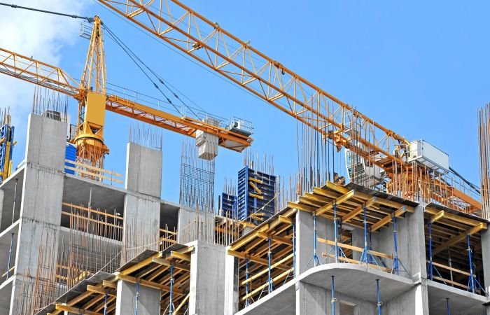 Crane and building construction site against blue sky