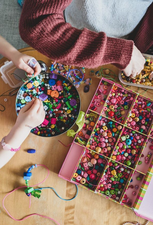 People using colourful beads to create a DIY project