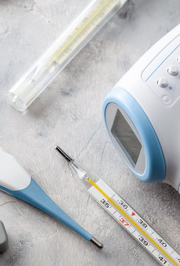 Electronic thermometer for measuring body temperature. Set of electronic thermometer, rectal, oral and glass on gray background.