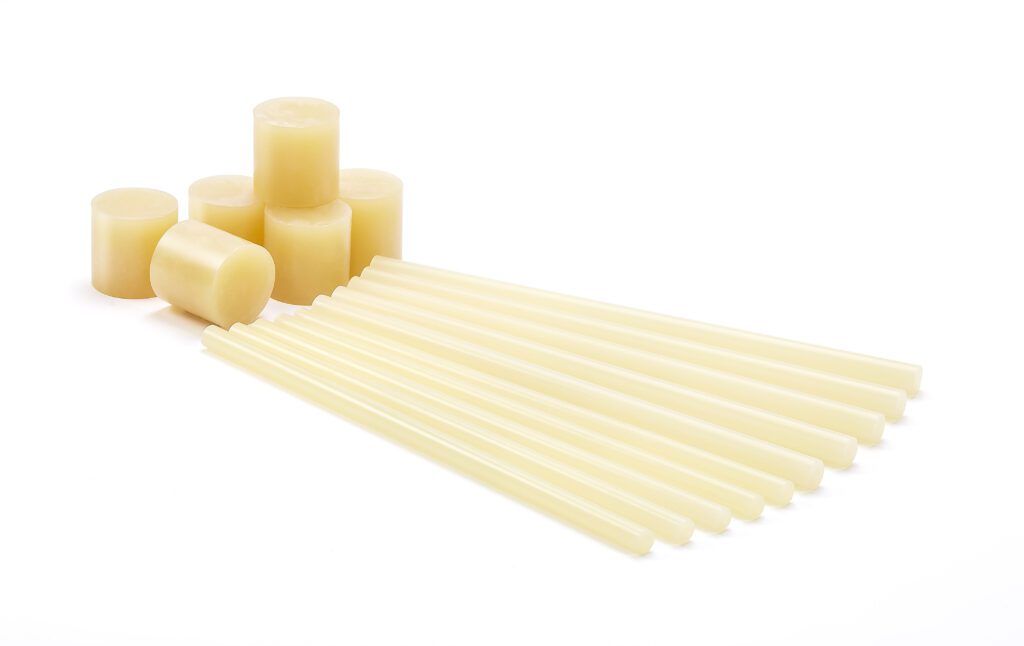 An assortment of stick and slug formats of Tecbond 214B on a white background.