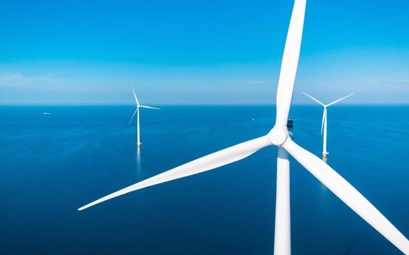Offshore wind farm with a bright blue sky behind